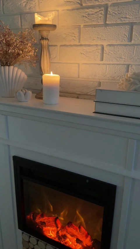Camera panning down from candles to glowing electric fireplace in dim room Stock-Footage 346084654