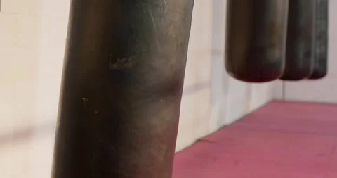 Camera panning downward revealing heavy bag and focus mitts resting on mat, 스톡 동영상 340986390