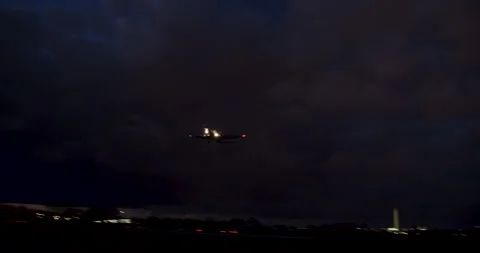 Camera Panning To Follow Plane On Approach To Landing At Night Stock Footage 228314602