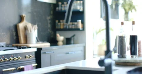 Camera is panning left and is racking focus on island, revealing black faucet, Stock Footage 345036581