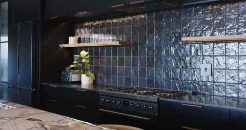 Camera is panning left, revealing black gas range, glossy tiled backsplash, Vídeo Stock 339652101