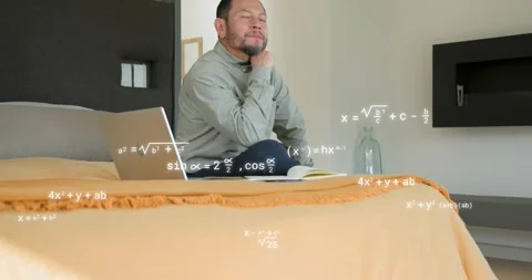Camera panning to man on bed opening laptop solving educational math problems Stock Footage 318307365