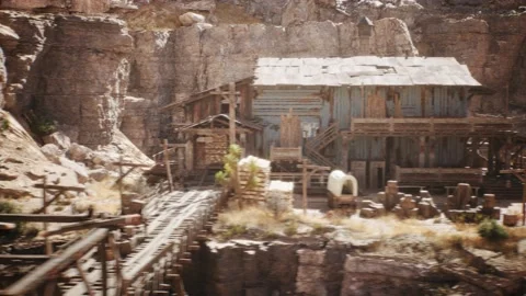 Camera is panning by an old western mine next to a west town village Stock Footage 236395686