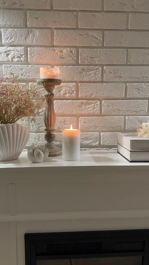 Camera panning over candles, dried flowers and decor on wooden fireplace mantle Stock Footage 346084413