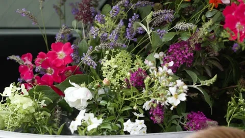 Camera panning over a canister filled with a variety of wildflowers. Stock Footage 239094338
