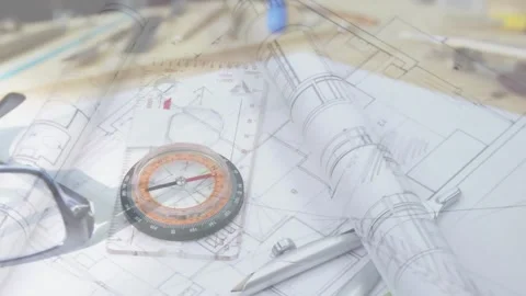 Camera panning over design desk, causing plans unrolling and glasses settling on Stock Footage 330427813
