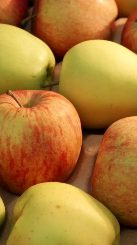 Camera panning over fresh green and red apples in wooden crate vertical Stock Footage 339299480