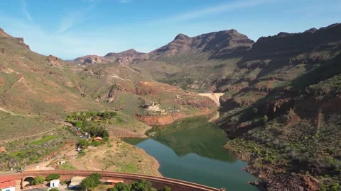 Camera panning over lake surrounded by mountains Stock Footage 293158235