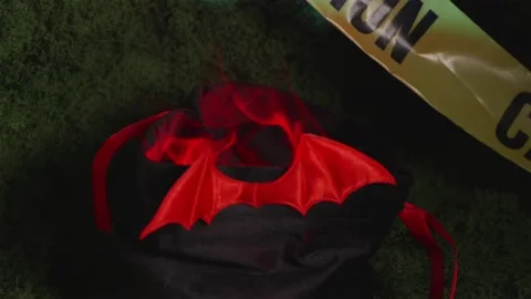 Camera panning over moss with caution tape and Halloween candy bag Stock-Footage 342520380