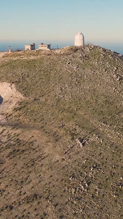 Camera panning over mountain observatory revealing vast landscape Stock Footage 290449964