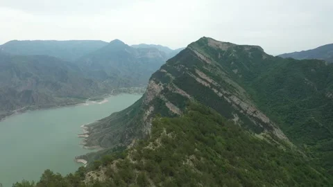 Camera panning over mountain peak with lake Видео 290176594