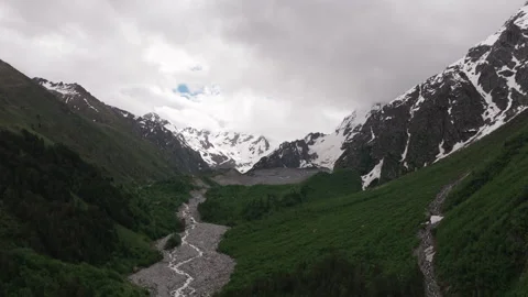 Camera panning over mountain valley with glacier Stock Footage 289648242