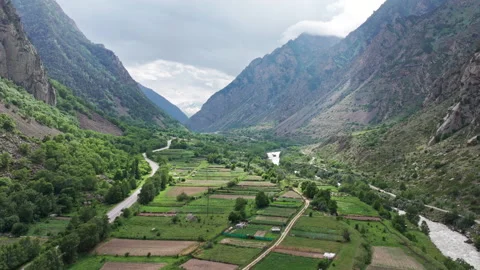Camera panning over mountain valley farmland Stock Footage 289661089