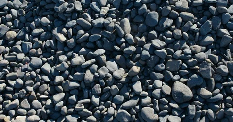 Camera panning over rocky beach of large grey pebbles - 4K. Stock Footage 87824938