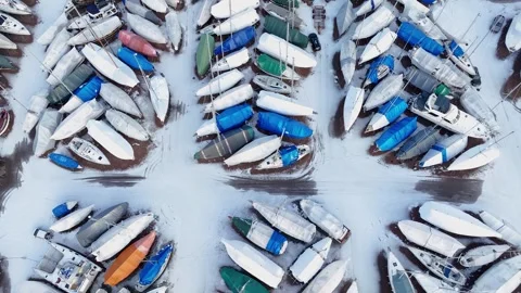 Camera panning over sailboats covered in snow, aerial drone view. Stock Footage 301201286