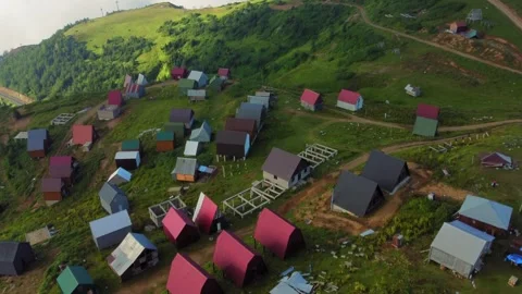 Camera panning over small village nestled in mountain valley Stock Footage 292803995