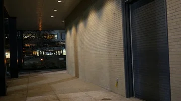 Camera panning over to warehouse hangar door at night Stock Footage 86001227