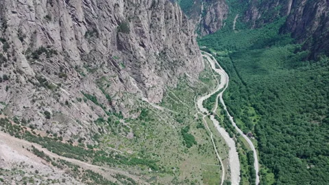 Camera panning over winding river in mountain valley Stock Footage 289639994