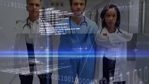 Camera panning revealing three professionals in hospital corridor; binary data Video stock 320128547