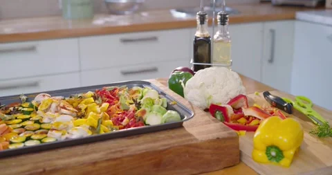 Camera is panning, revealing tray of sliced vegetables and cutting board on Stock Footage 339678796