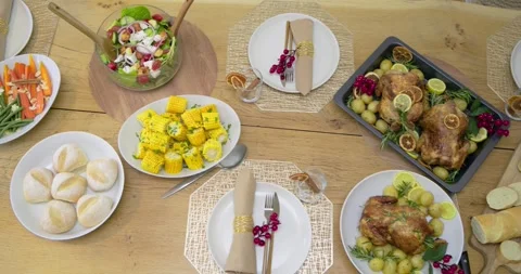 Camera is panning right across set wooden table revealing roast chickens, salad, Stock Footage 341664737