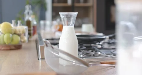 Camera is panning right and pulling focus, bringing milk carafe forward for Stock Footage 344851328