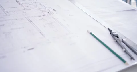 Camera is panning right, moving closer to show pencil and compass on blueprint Stock Footage 344645743