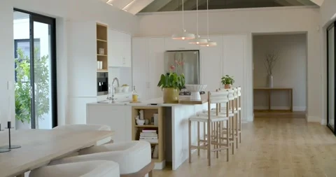 Camera is panning right revealing island, stools and dining table by sliding Stock Footage 340986971