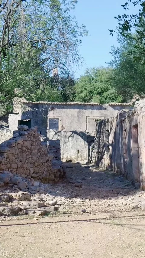 Camera panning right showing abandoned stone houses Stock Footage 294963979