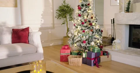 Camera is panning rightward, centering Christmas tree and gifts while showing Stock Footage 344461194