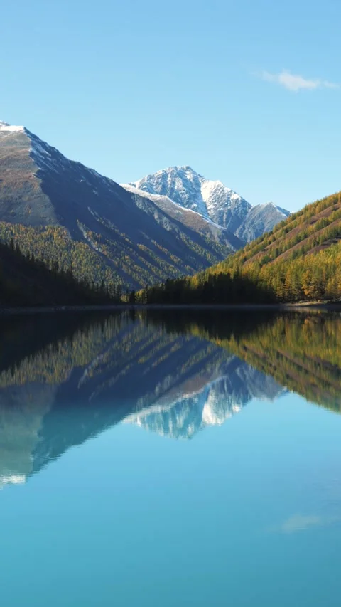 Camera panning showing mountain range reflecting on lake surface Stock Footage 292386794