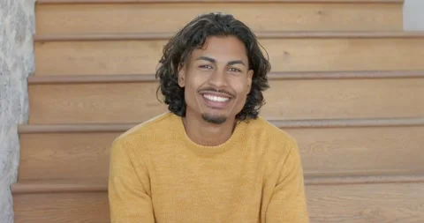 Camera panning showing stone wall as man wearing yellow sweater sitting on Stock Footage 341320177