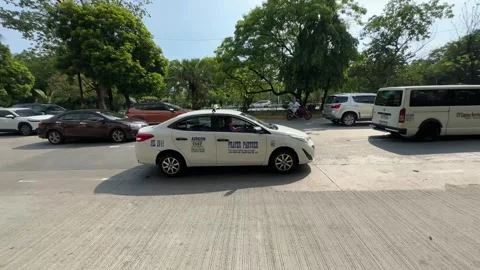 Camera panning tracking a white taxi driving on Manila street 4K 库存影片 337451099