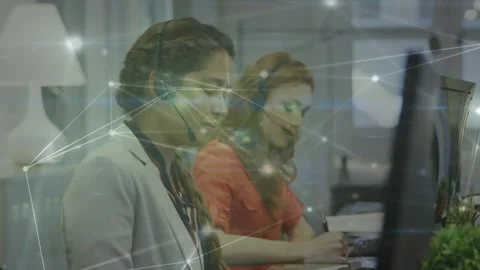 Camera panning two call agents one talking as other writing net overlay on Stock Footage 330936199