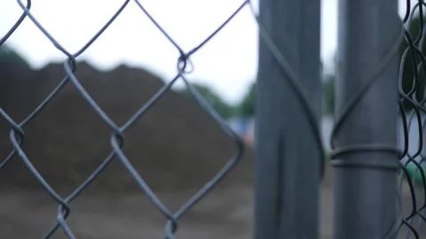 Camera Pans Across Blurry Construction Site Through Chain Link Fence Stock Footage 310864496
