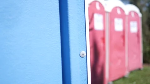 Camera pans across defocused outside bathrooms or port-a-potty Stock Footage 286915384
