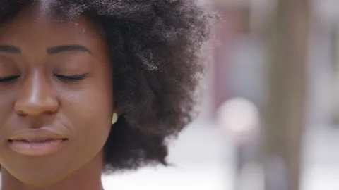 Camera pans across the face of a serene young woman standing with her eyes close 스톡 동영상 159011973