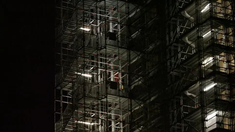 Camera pans across a high rise building scaffolding Stock Footage 84006395