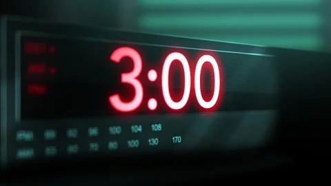 Camera pans across old digital clock as time arrives at 3 AM Stock Footage 306501792