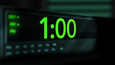 Camera pans across old digital clock as time arrives at 1 AM - Green Version Stock Footage 306557949