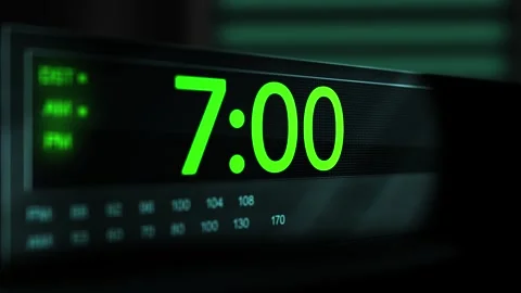 Camera pans across old digital clock as time arrives at 7 AM - Green Version Stock Footage 306583811
