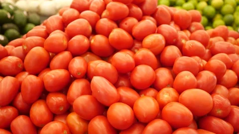 Camera pans across a pile of Roma tomatoes in Grocery Store Stock Footage 289403377