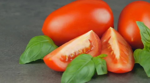 Camera pans across red plum tomatoes and basil Video stock 65728043