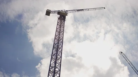 Camera pans across a sky of industrial construction cranes above Stock Footage 107899359