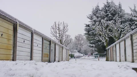 Camera pans across snow covered residential garages 스톡 동영상 225707462
