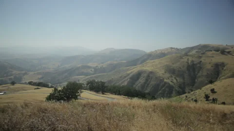 Camera pans across top of rolling hills of grass Stockbeeldmateriaal 31742620