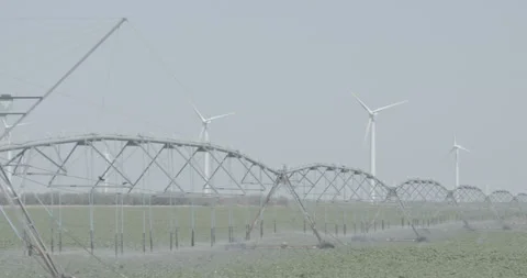 Camera Pans Across Windmills in Front of Field Stock Footage 134341445