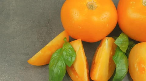 Camera pans across yellow tomatoes and basil with water drops Stock Footage 65728276