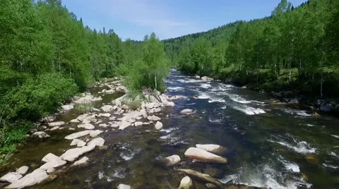 The camera pans along the river a small mountain river (quadrocopter) Video stock 67215126
