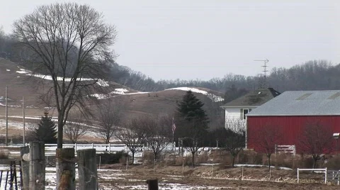 The camera pans an American farm with red barns and silos Stock Footage
